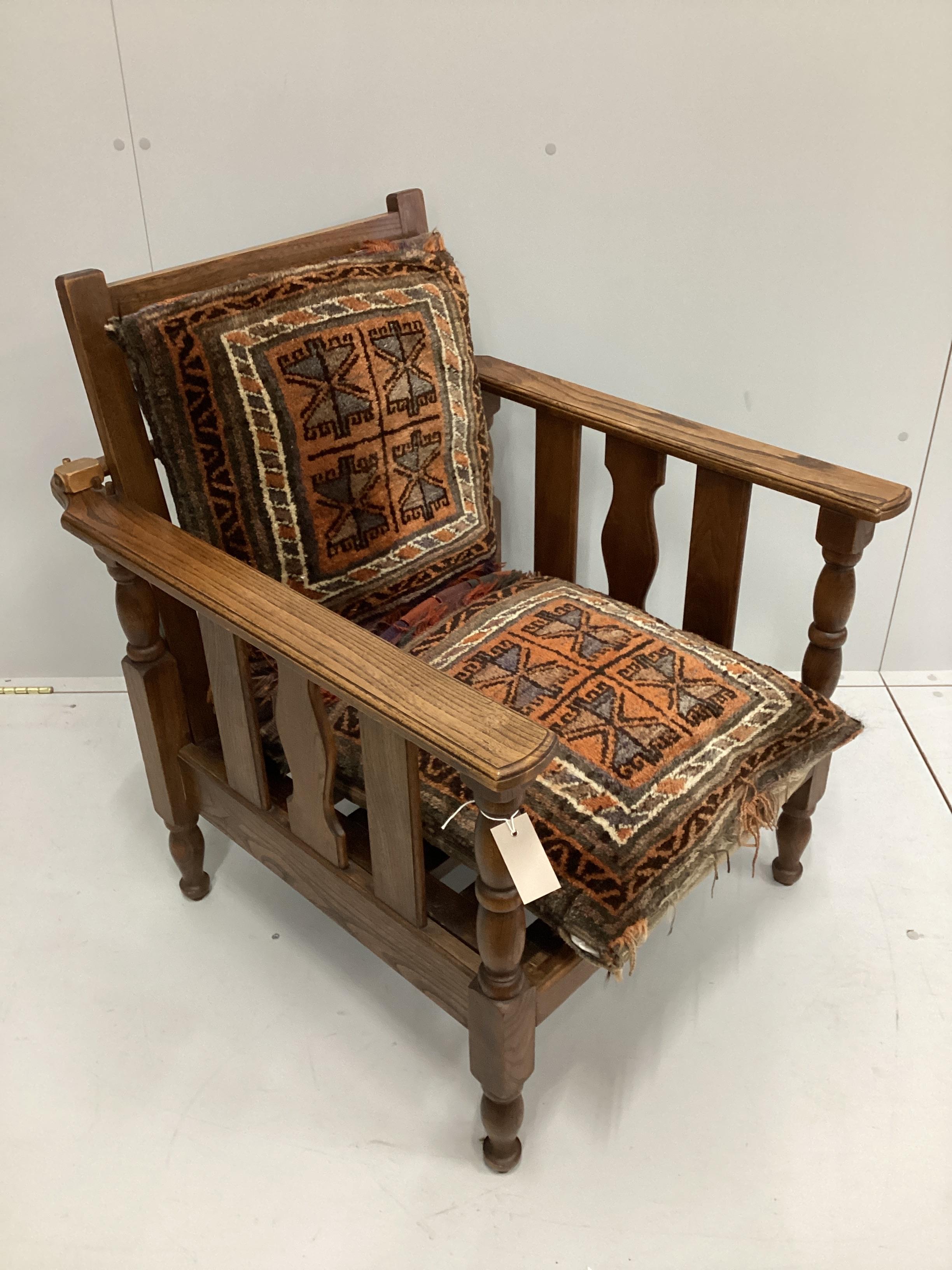 An early 20th oak reclining armchair with geometric saddlebag cushion seat and back width 70cm, depth 79cm, height 86cm.